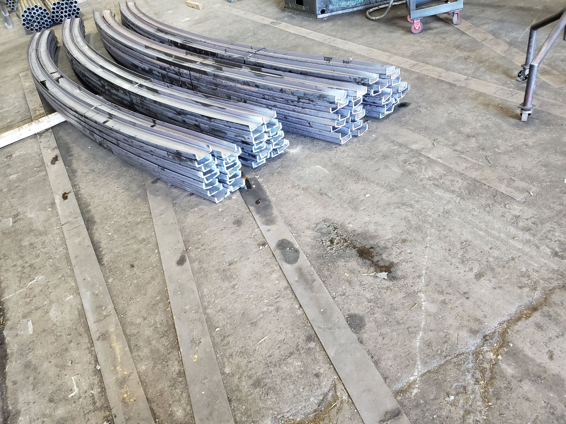 A bunch of metal pieces are stacked on top of each other on the floor.