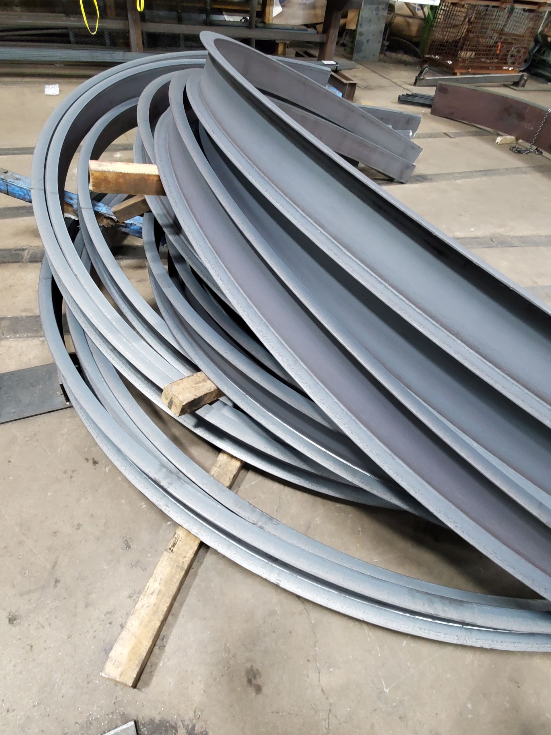 A bunch of metal pipes are stacked on top of each other on the floor.