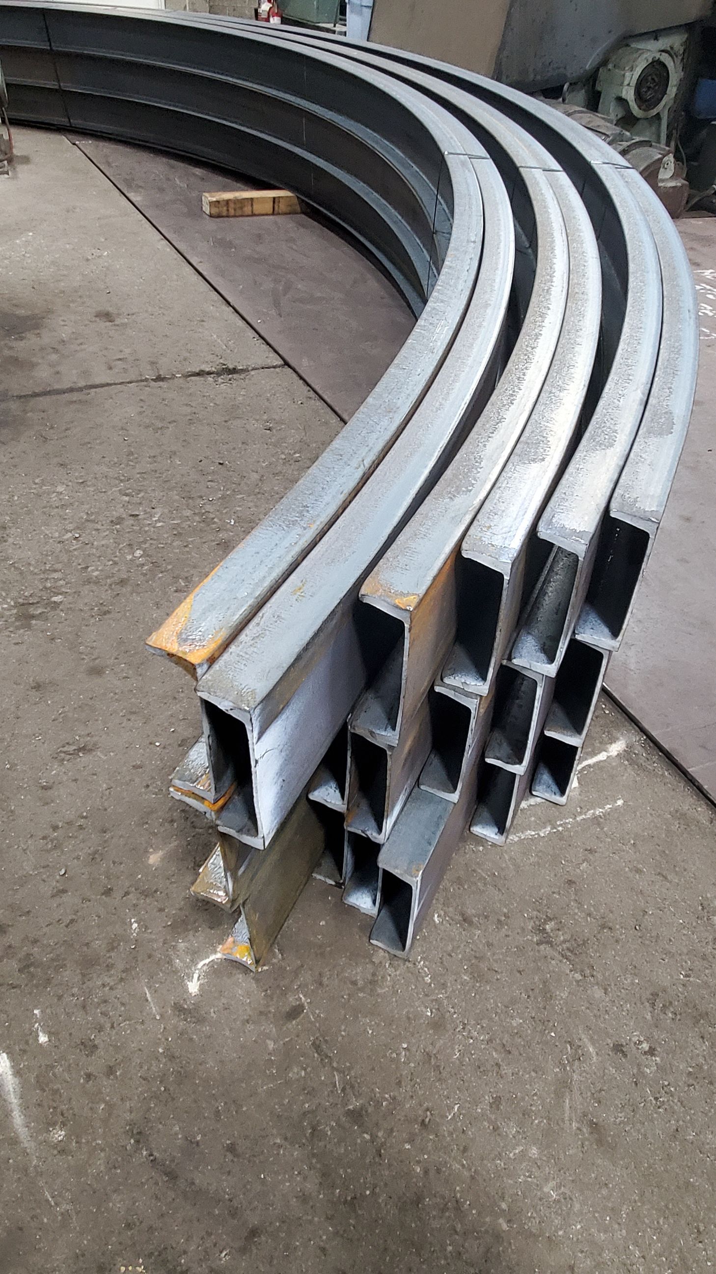 A bunch of metal pipes are stacked on top of each other on the ground.