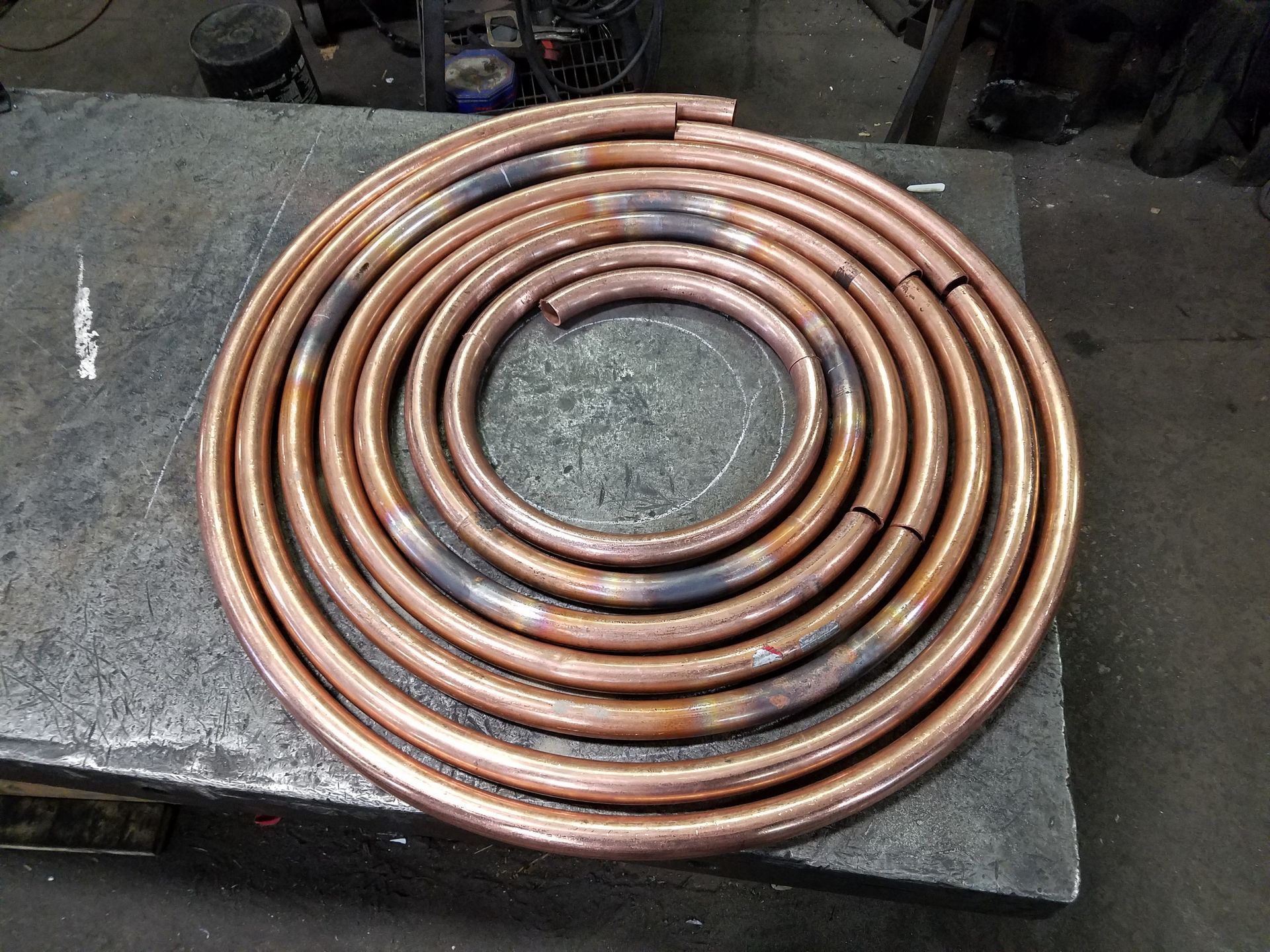 A spiral of copper pipes is sitting on a table.