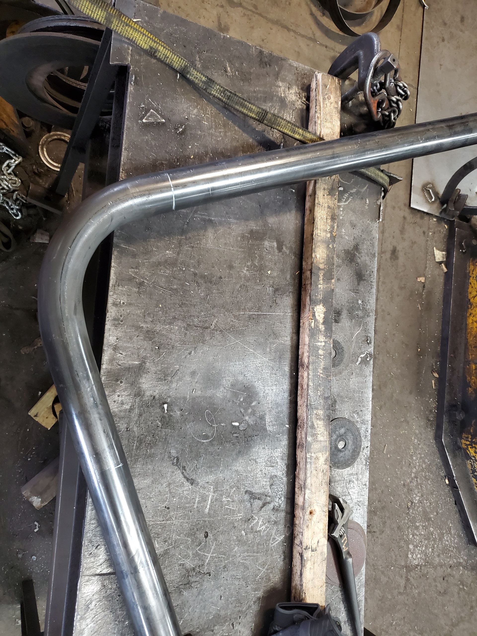 A metal pipe is sitting on top of a wooden table.