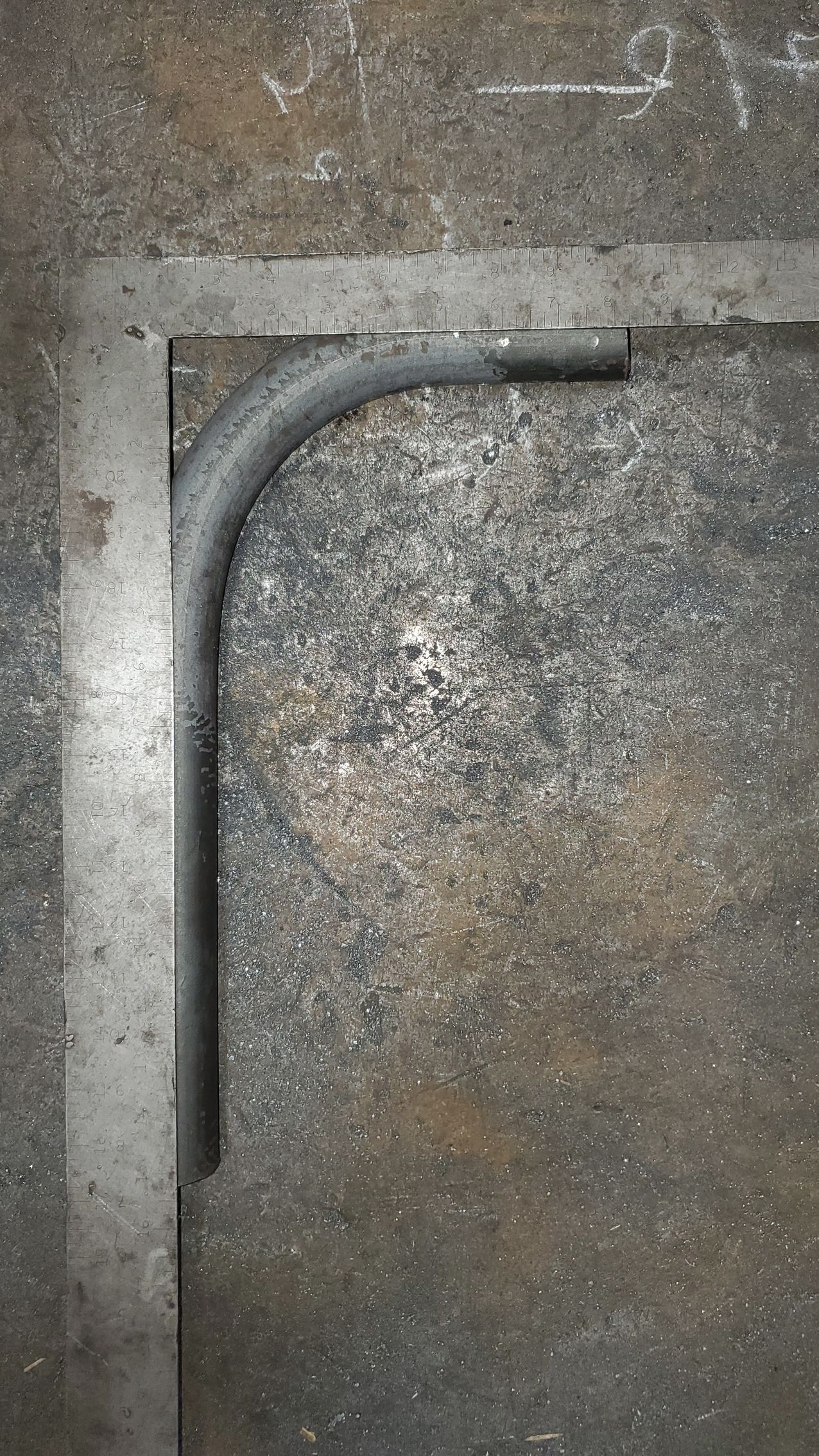 A close up of a metal pipe on a concrete surface.