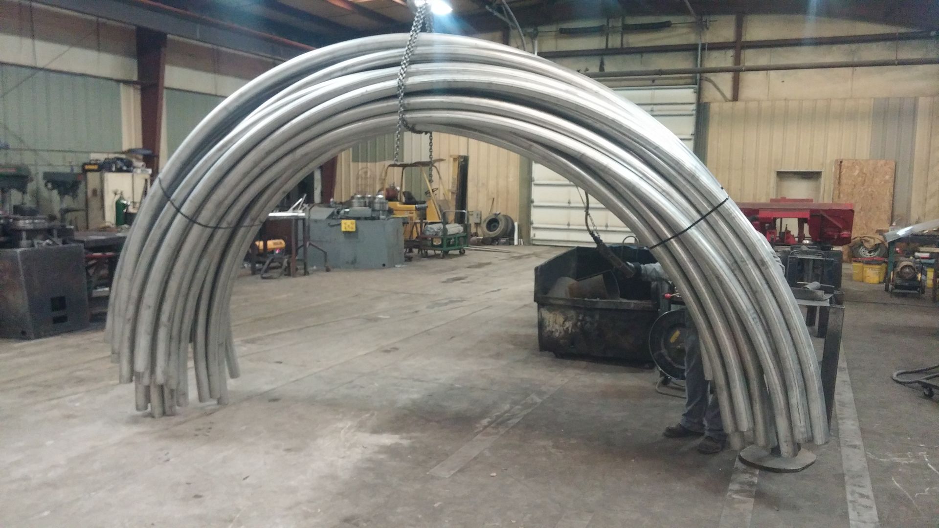 A bunch of metal pipes are stacked on top of each other in a factory.