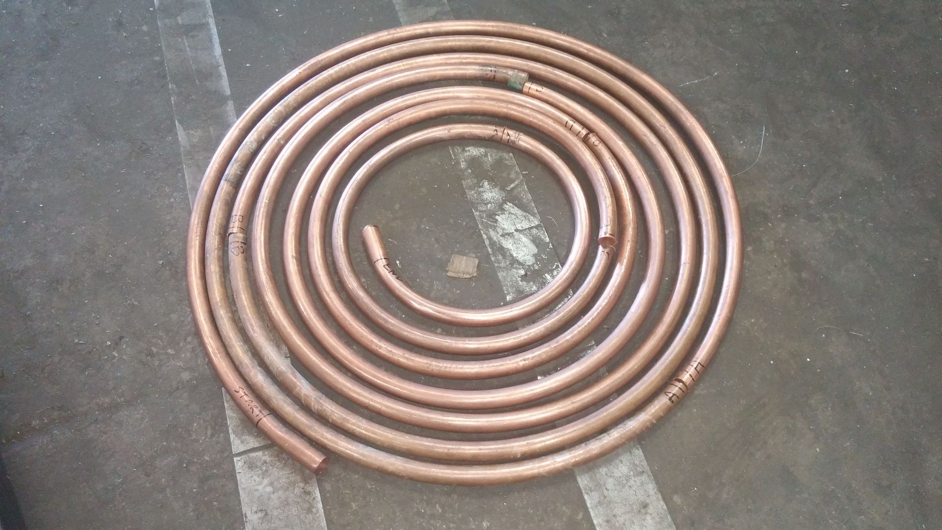 A spiral of copper pipes is laying on the ground