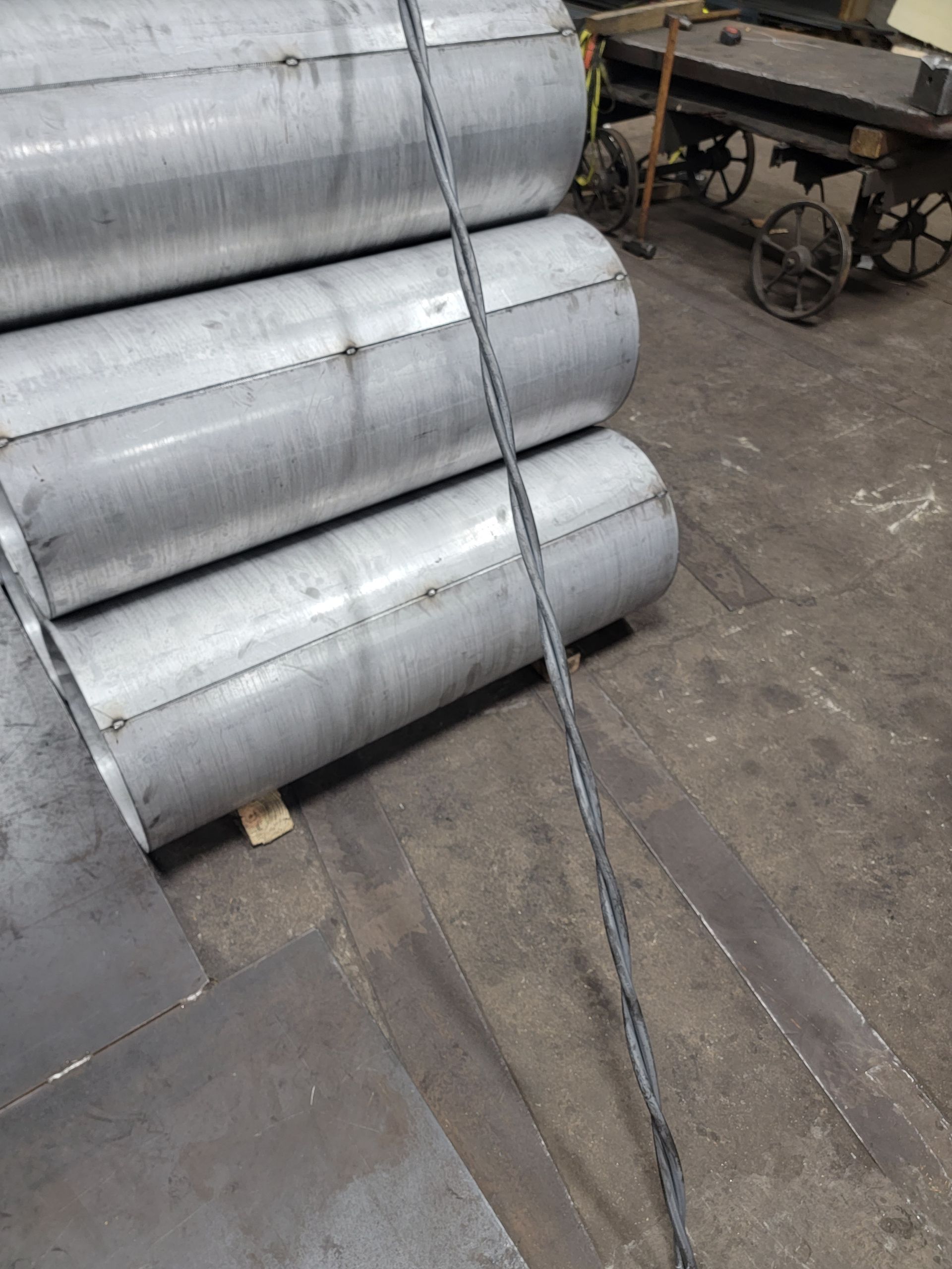 A bunch of metal pipes are stacked on top of each other in a factory.