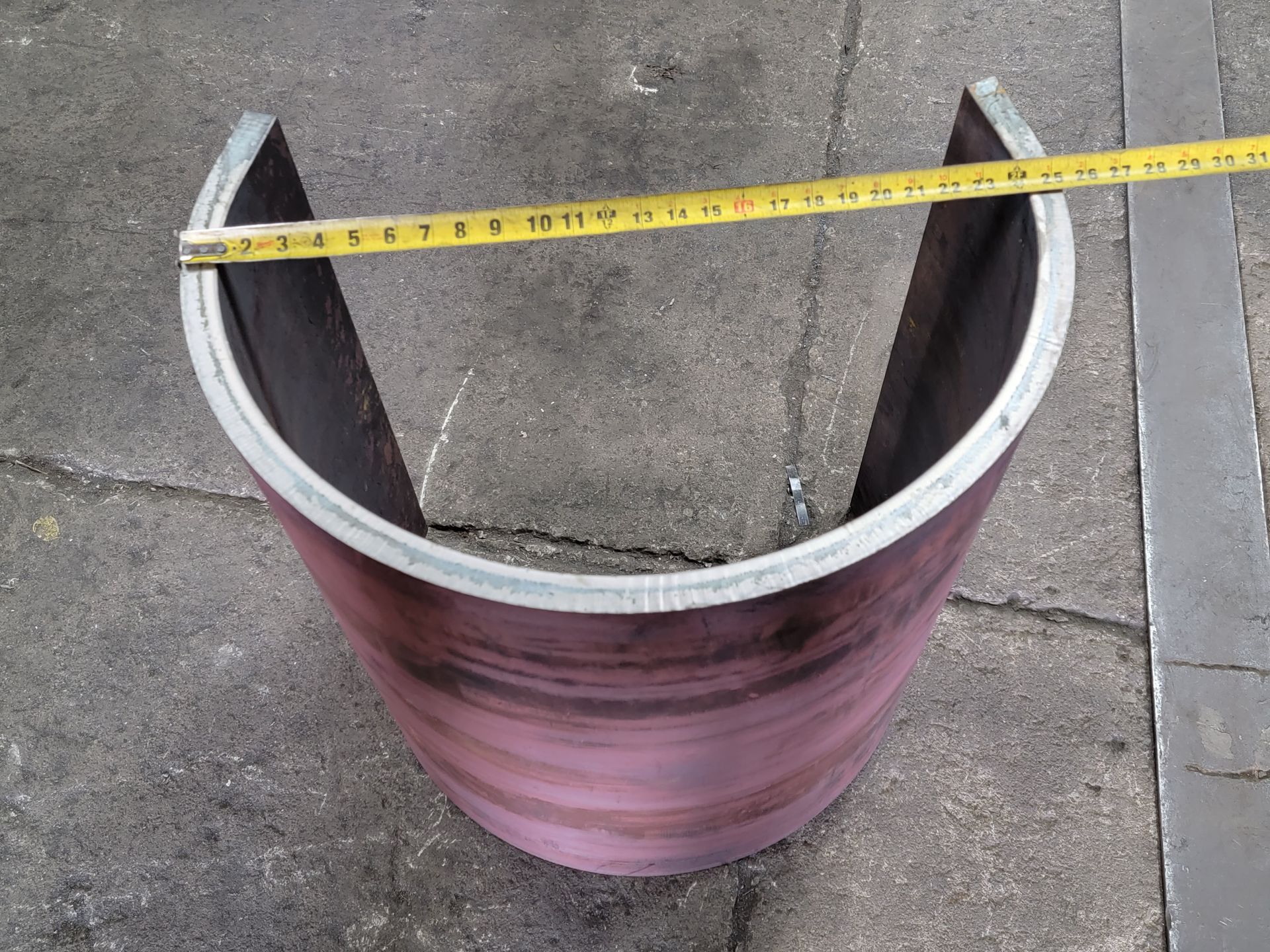 A piece of metal is being measured with a tape measure