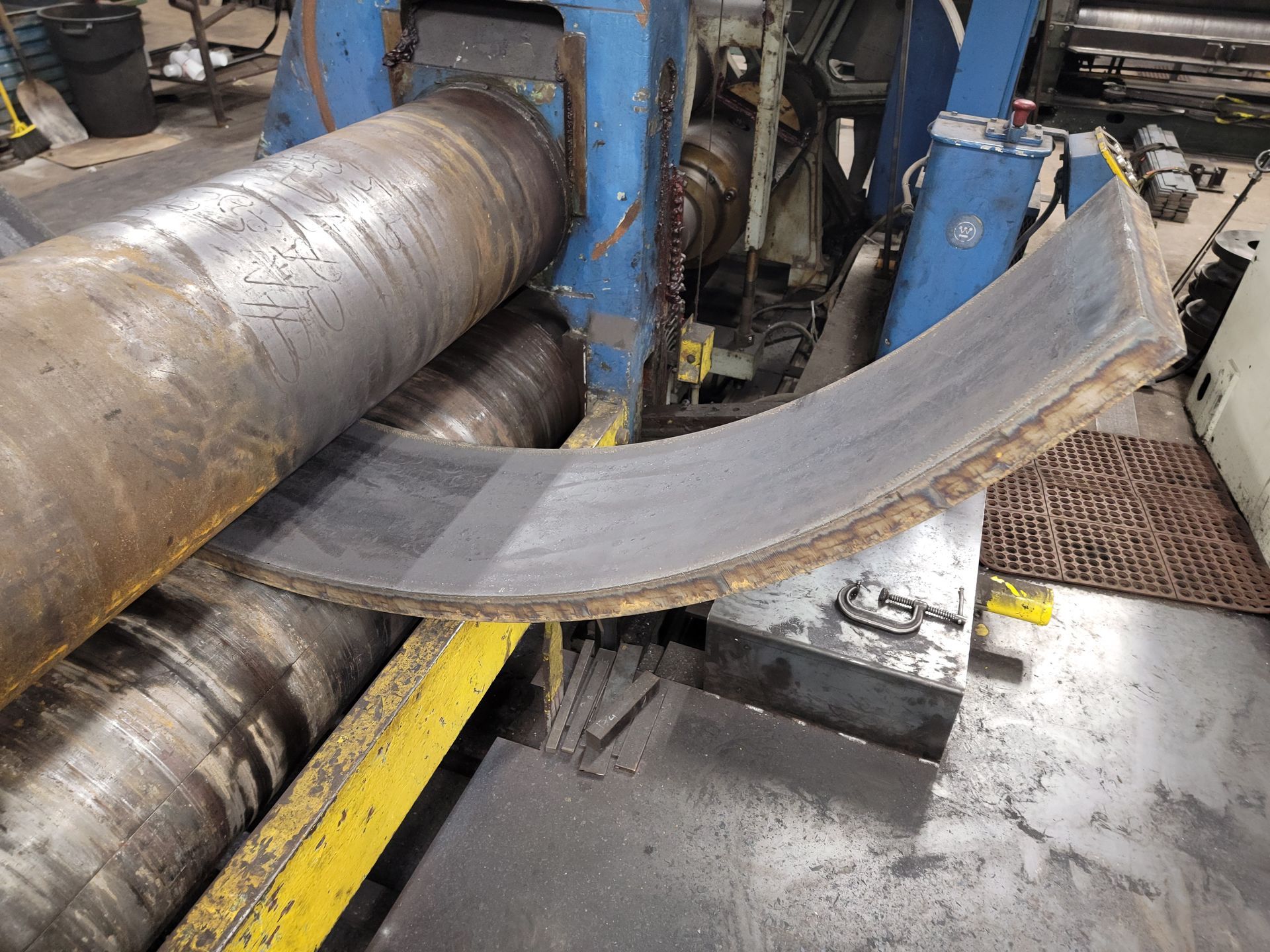 A piece of metal is being rolled on a machine in a factory.