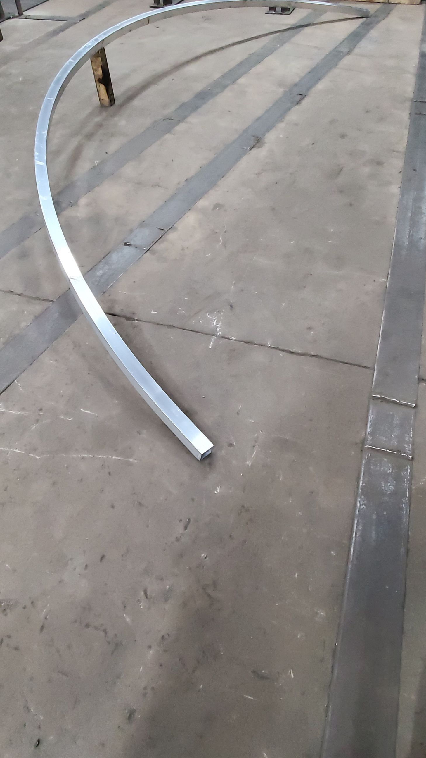 A metal pipe is sitting on a concrete floor.