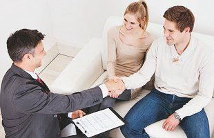 Insurance agent shaking hand with young couple