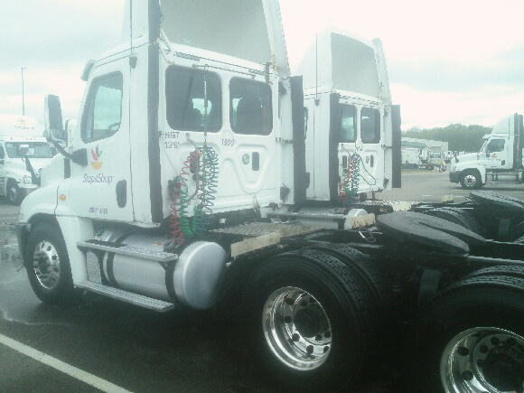 A white semi truck is parked in a parking lot