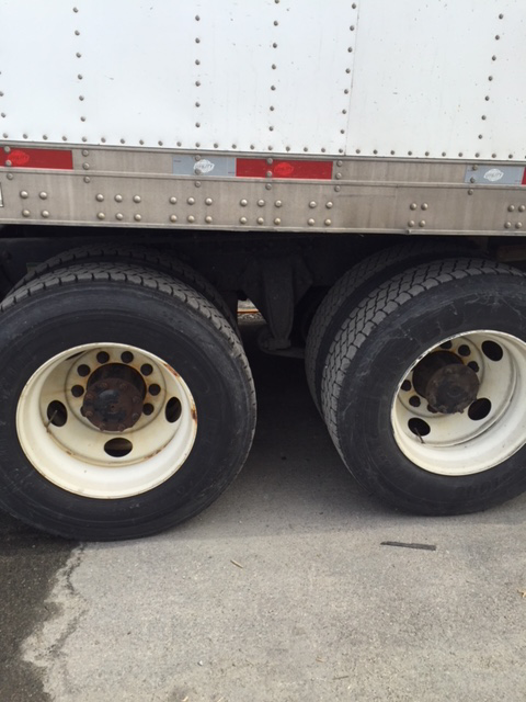 A white truck with black tires and white rims