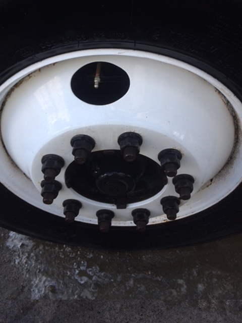 A close up of a white wheel with nuts on it