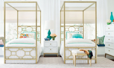 Two canopy beds are sitting next to each other in a bedroom.