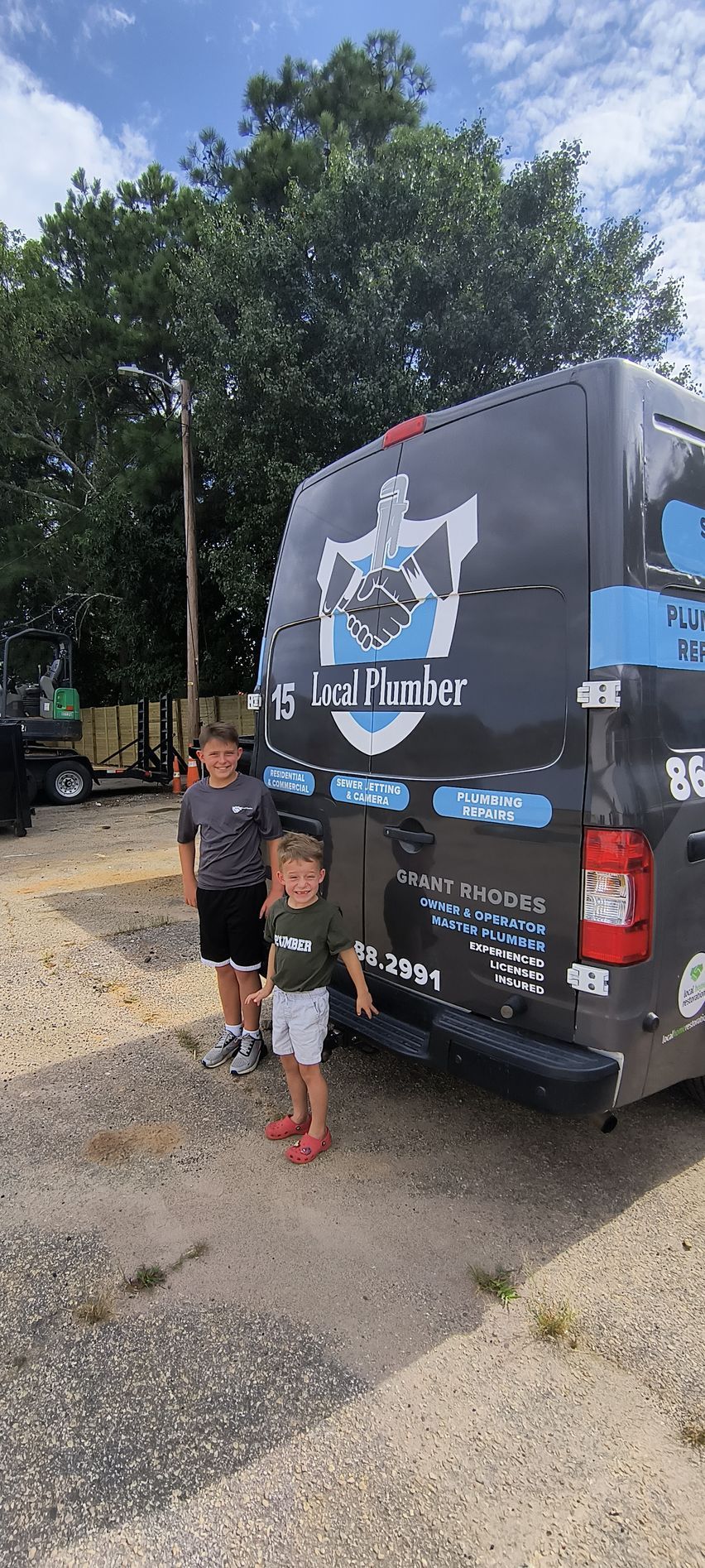 Two young boys are standing in front of a van.
