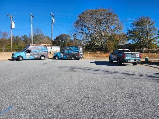 Three trucks and a van are parked in a parking lot.