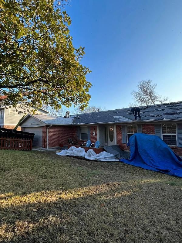 A man is working on the roof of a house.