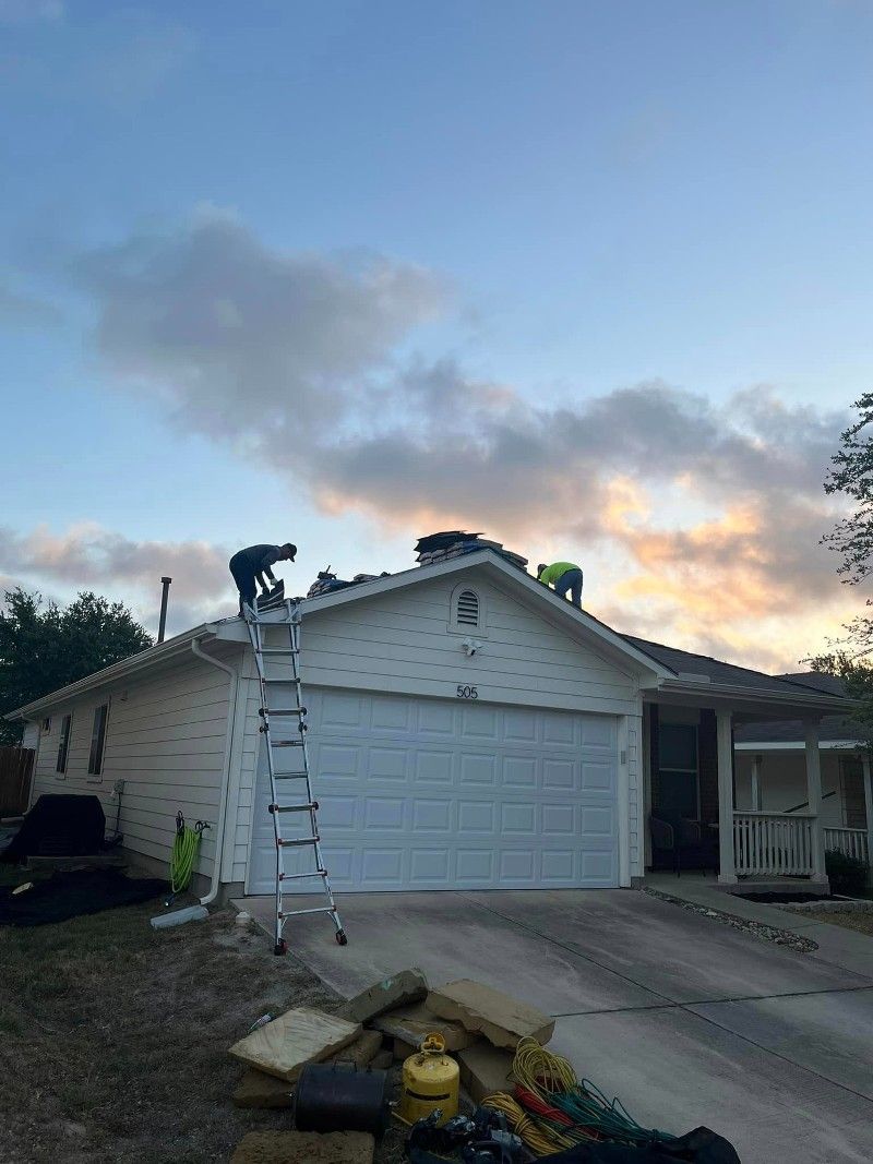 Two men are working on the roof of a house.