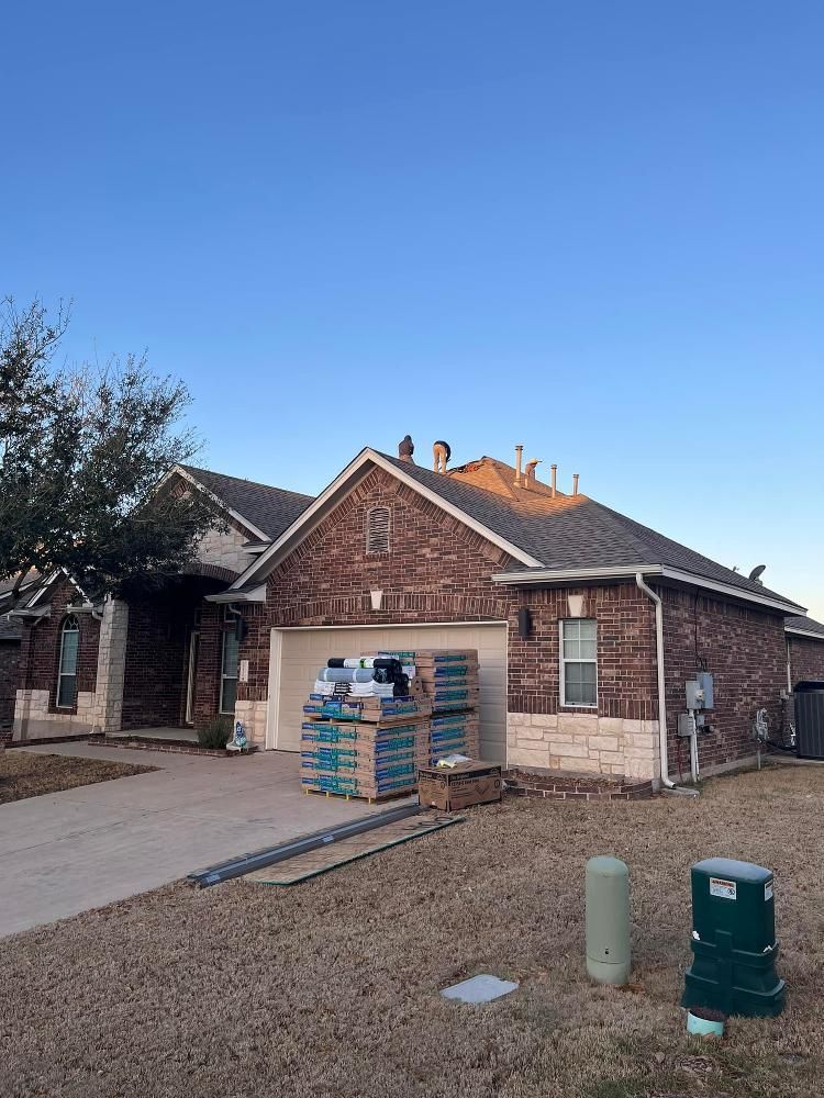 A brick house with a roof that is being installed.