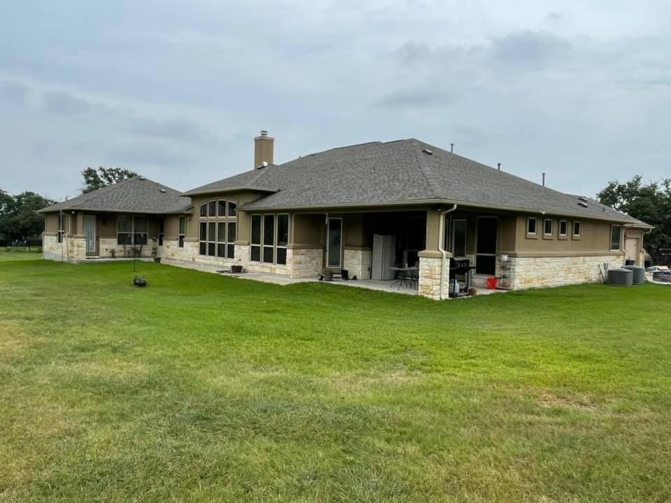 Two houses are sitting next to each other on a lush green field.