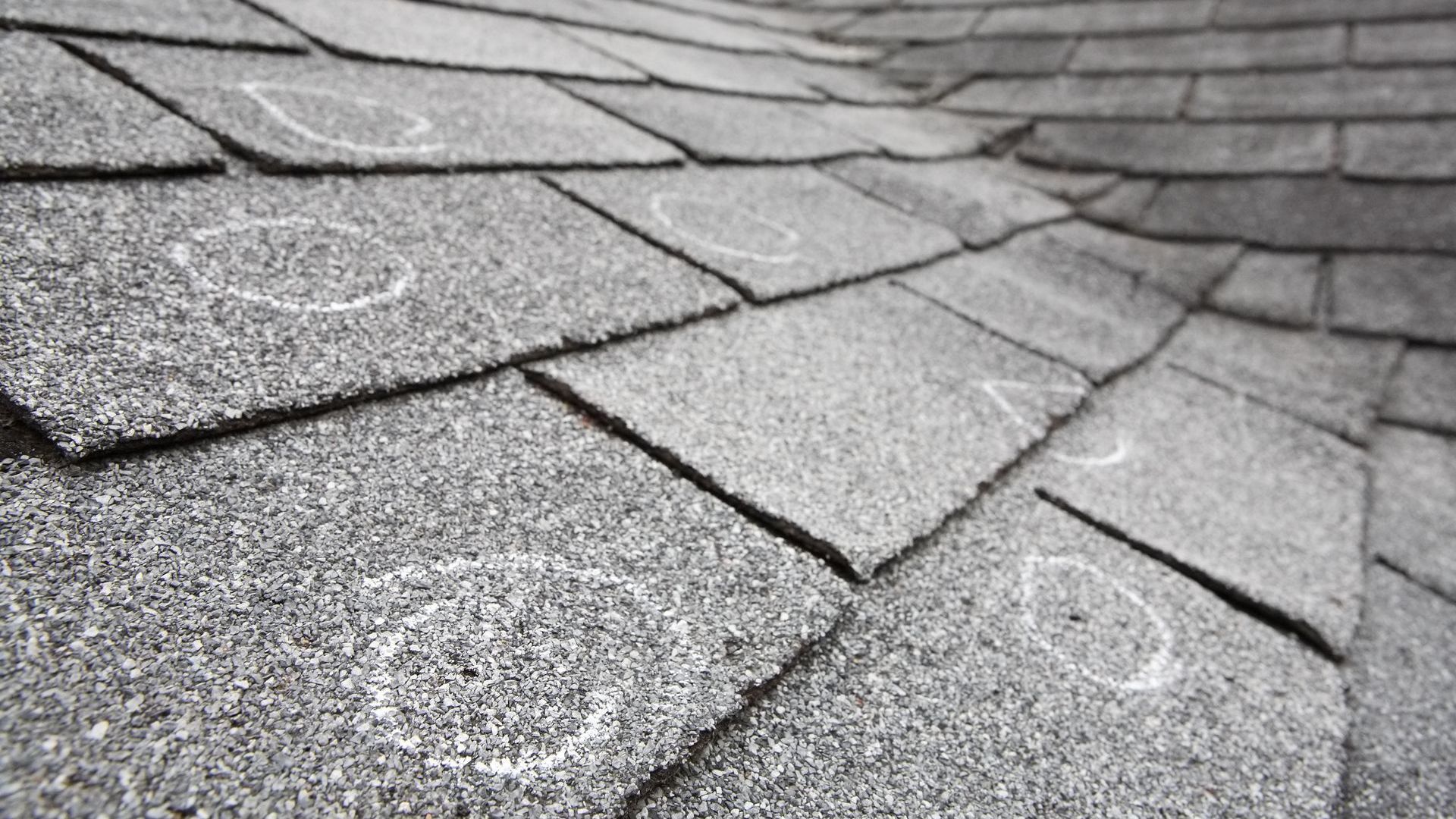 A black and white photo of a roof with hail damage.