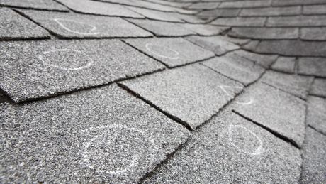 A black and white photo of a roof with hail damage.