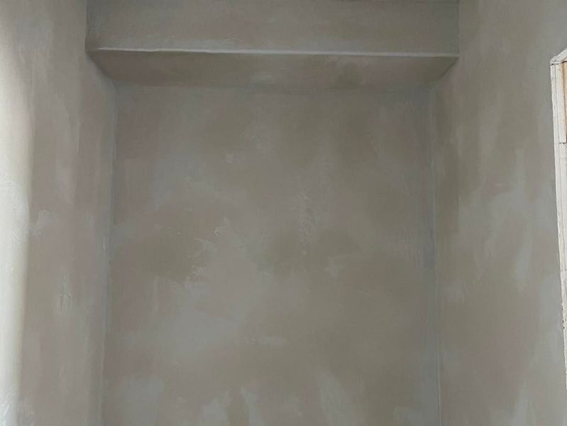 Gray plastered walls in an empty alcove with a recessed section above.