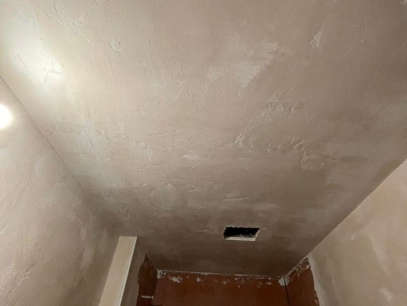 Newly plastered ceiling and walls in a room, light beige with a rectangular opening.