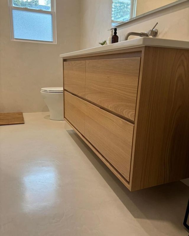 Modern bathroom with a light wood floating vanity and a white countertop.