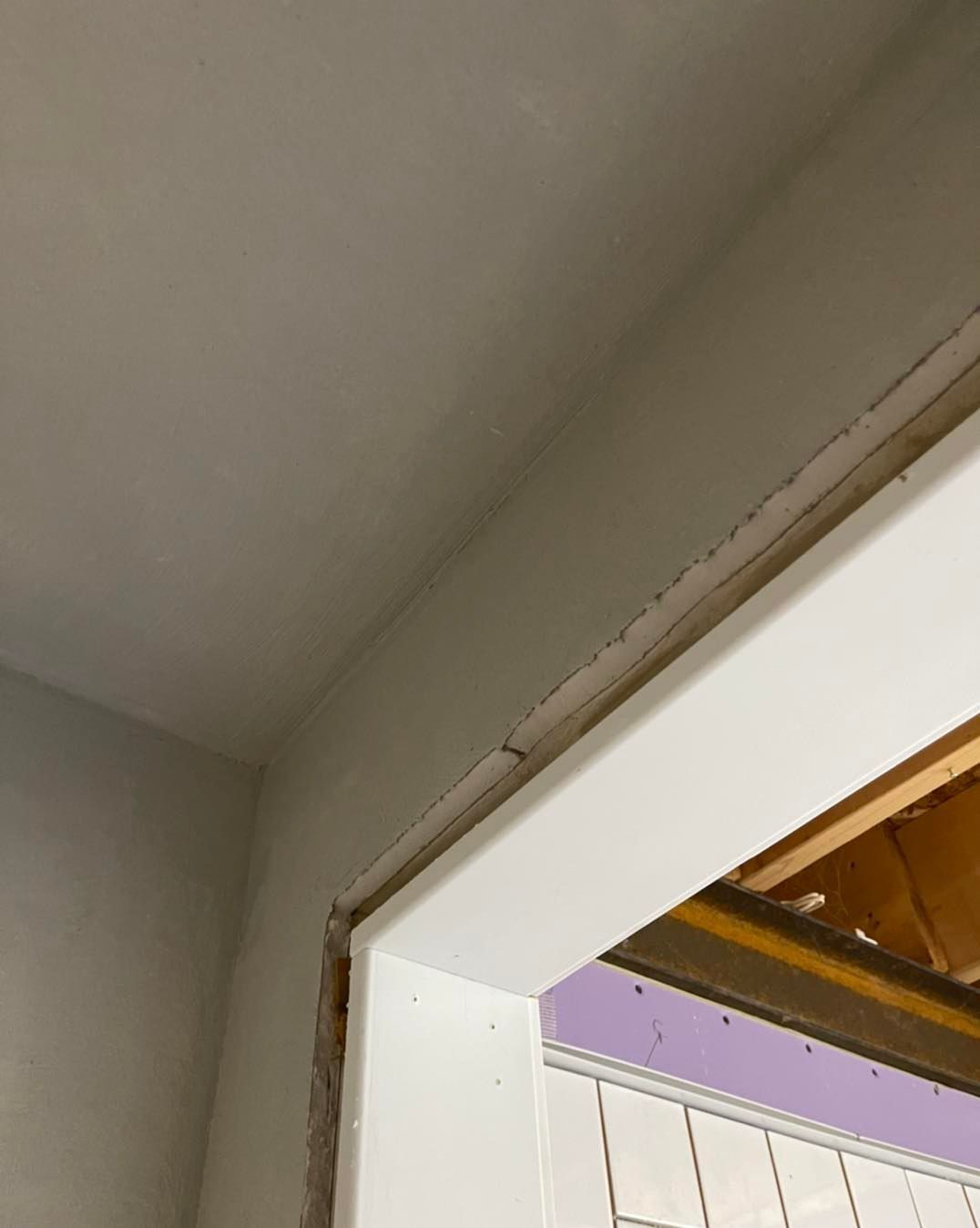 White door frame with surrounding wall. Freshly painted light gray walls.