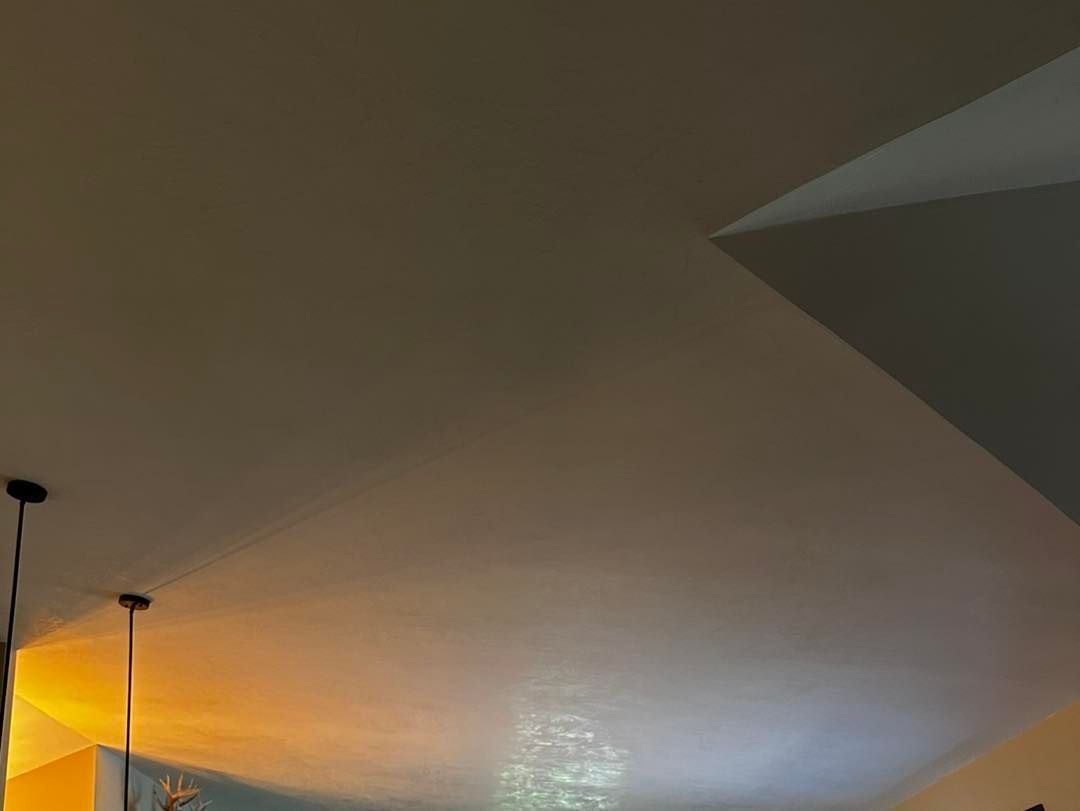 White ceiling with two black pendant lights and a section of a white wall.