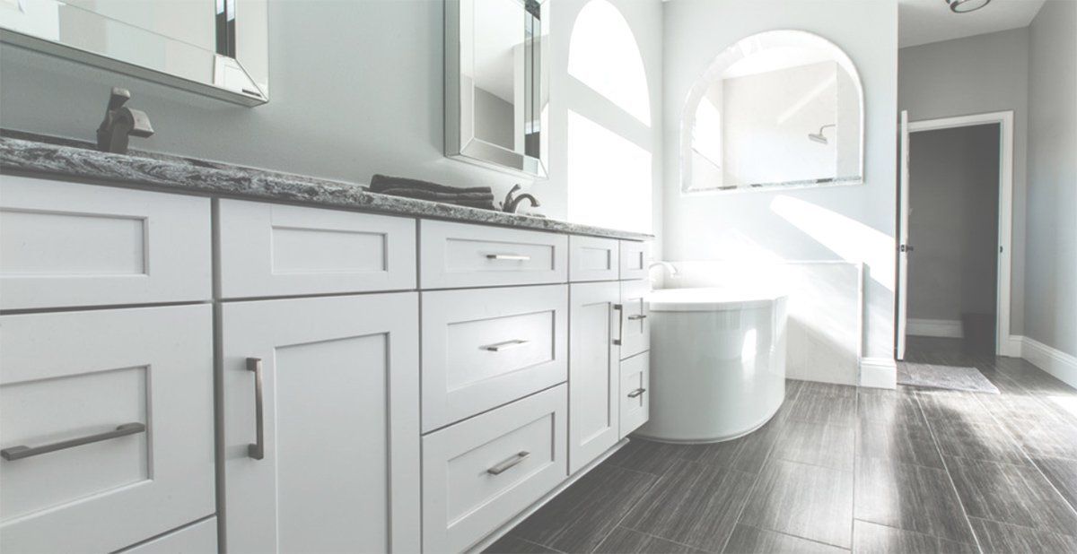 Bright white modern bathroom with vanity, tub, and sunlight on wood-look floor