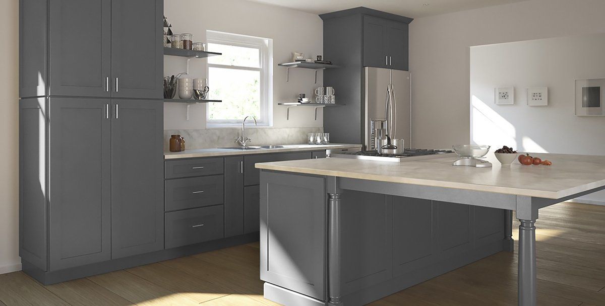Modern kitchen with gray cabinets, white island, and sunlit countertops