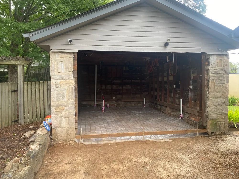 Open garage or workshop under construction with stone pillars and unfinished interior