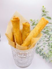 Fried egg rolls in a glass bowl on a table.