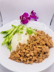 A white plate topped with ground chicken , rice and green beans.