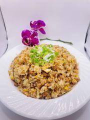 A white plate topped with fried rice and a purple flower.