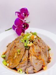 A close up of a plate of food with a purple flower in the background.