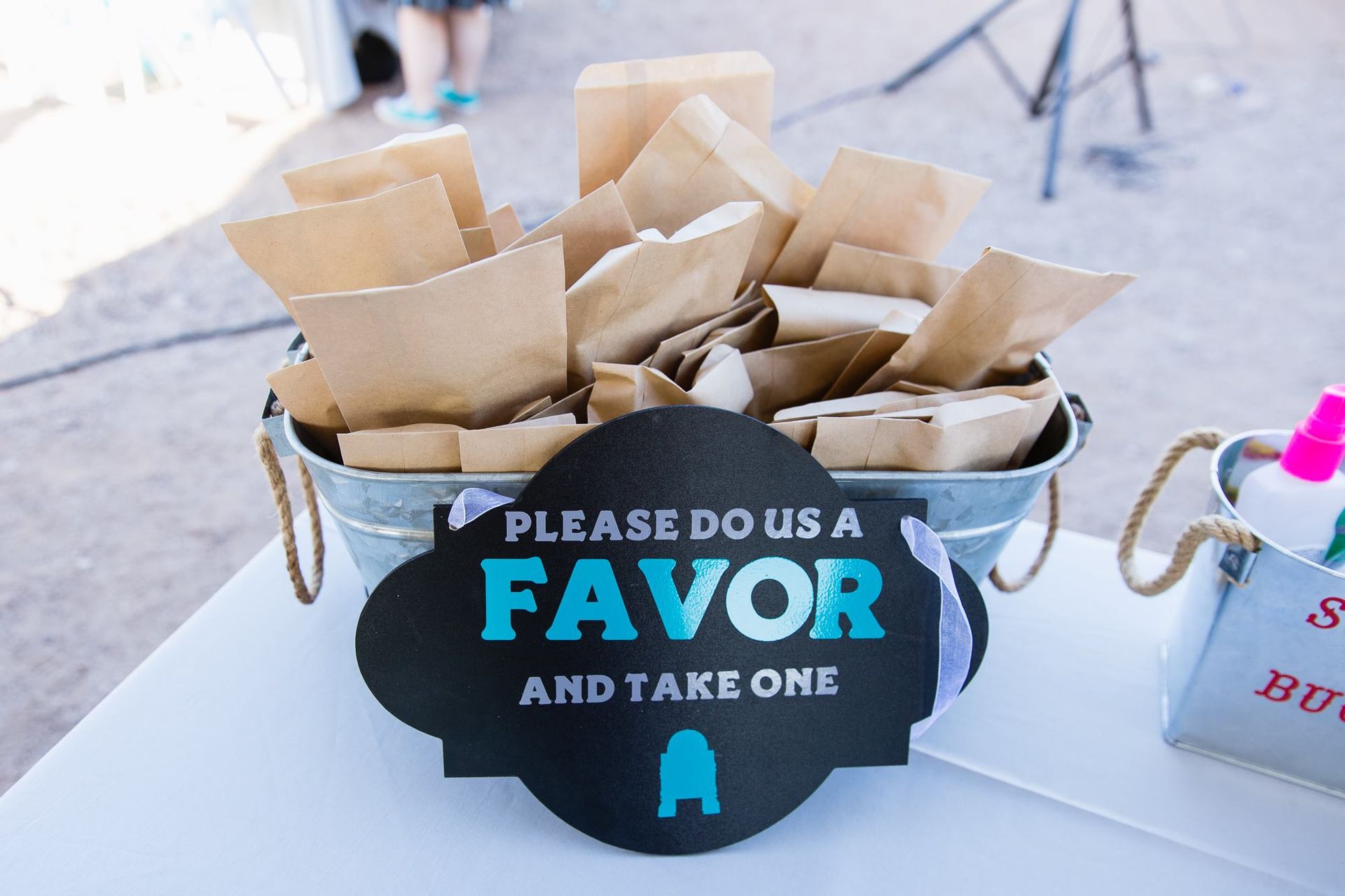 Paper bags in a basket with a sign reading “Please do us a favor and take one.”