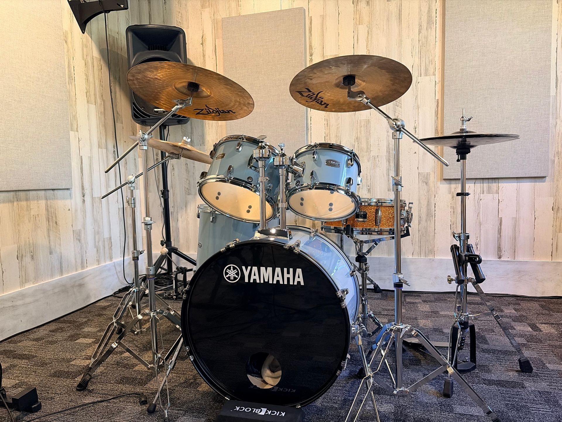 Yamaha drum kit in a small, textured practice room with cymbals and microphones