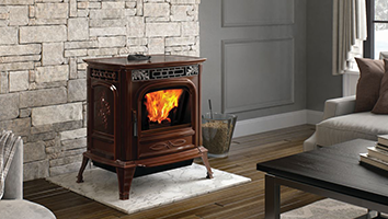 A wood stove is sitting in a living room next to a couch.