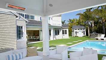 There is a swimming pool in the backyard of a house.