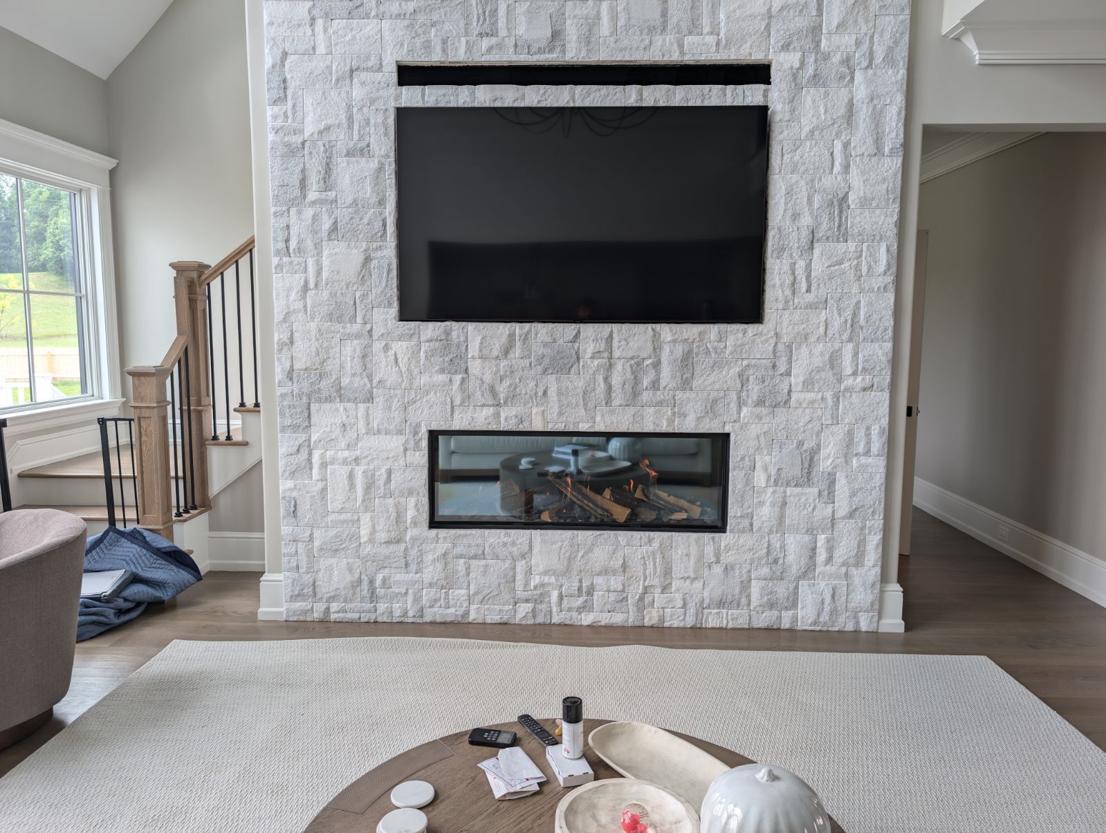 A living room with a fireplace and a flat screen tv on the wall.