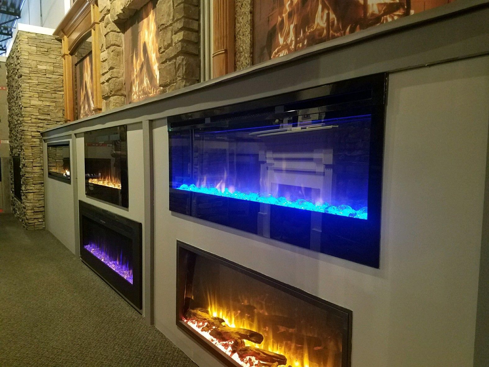A row of electric fireplace displays in a store.