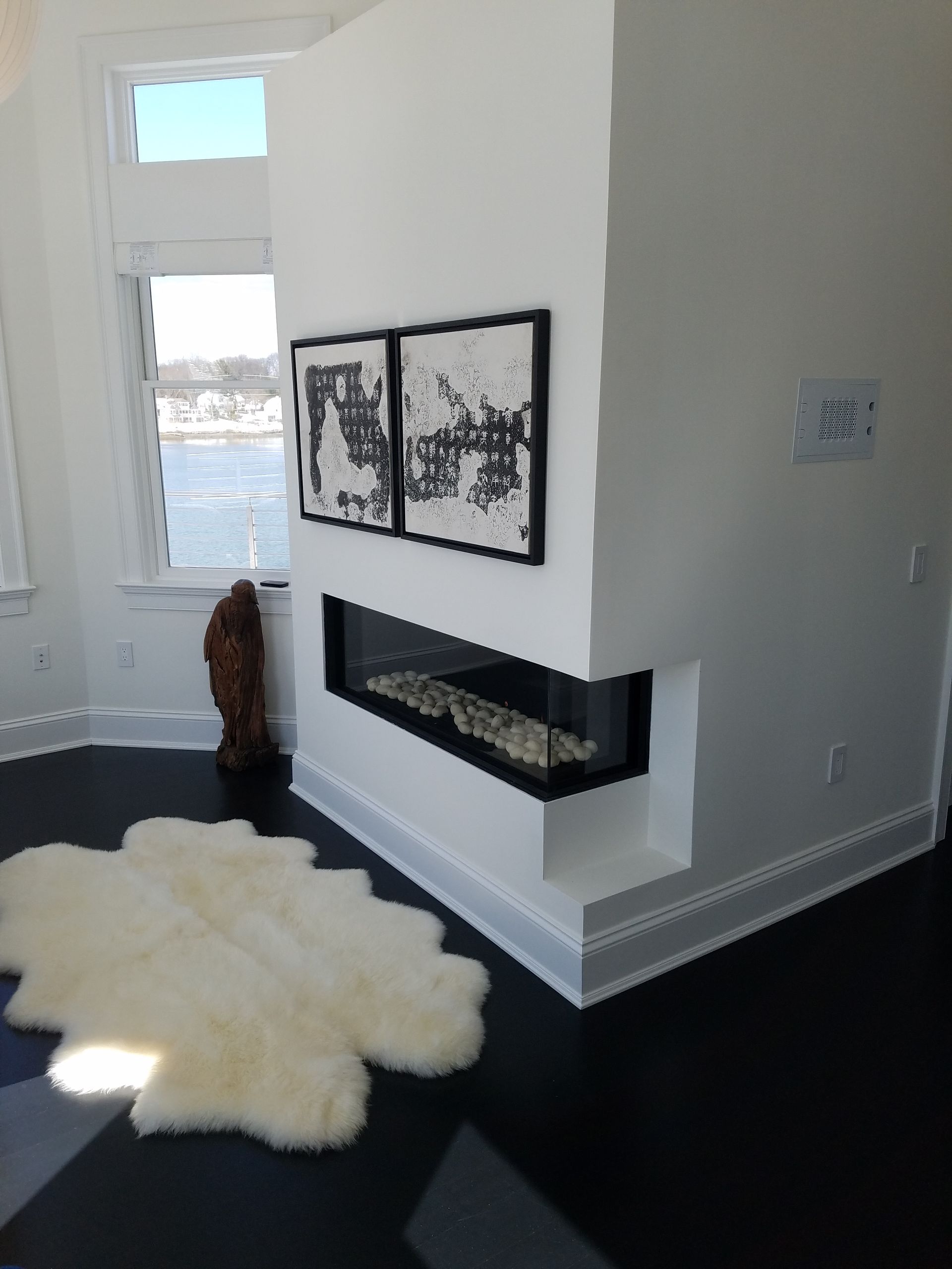 A living room with a fireplace and a rug on the floor.