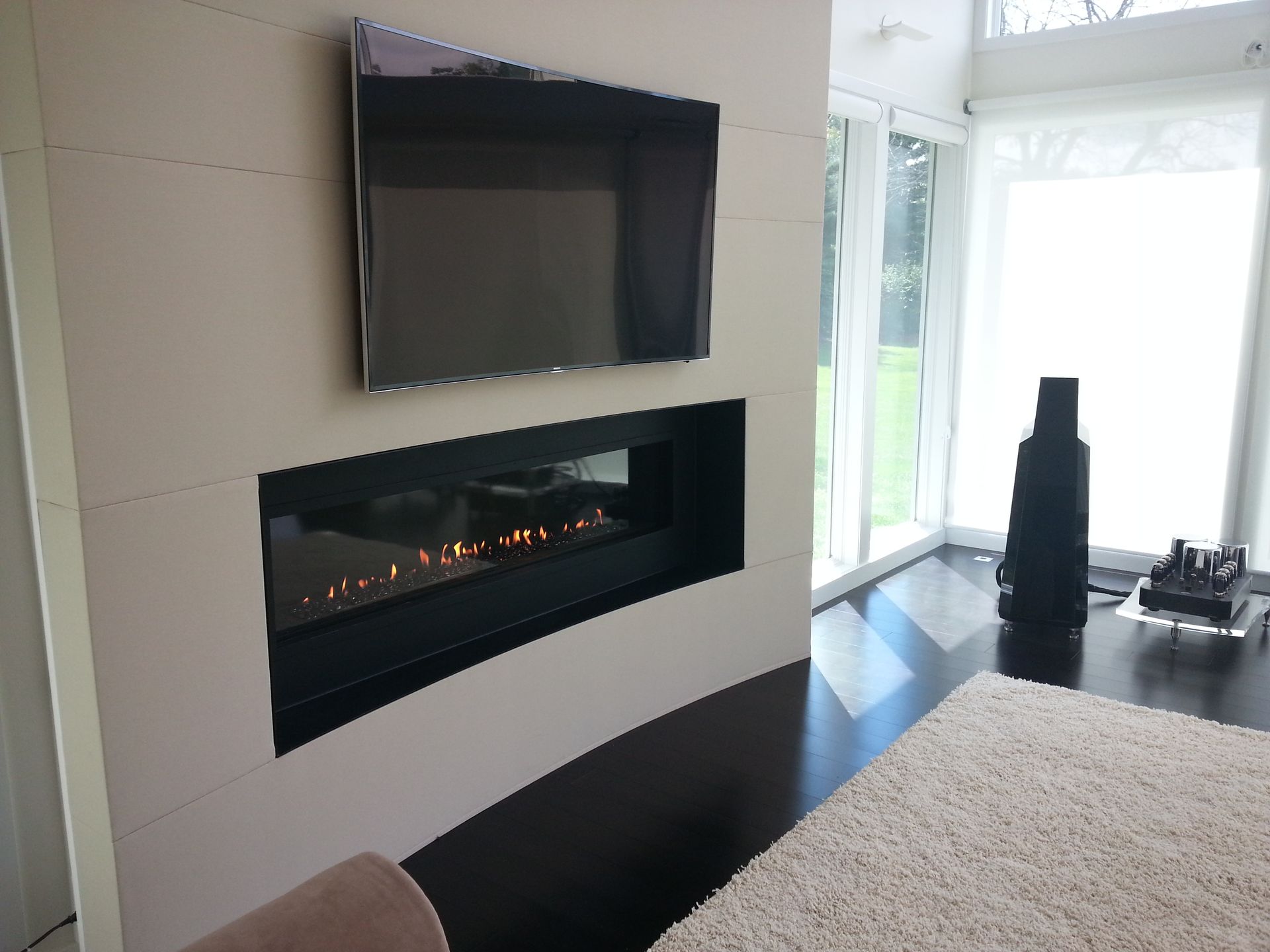 A living room with a fireplace and a flat screen tv