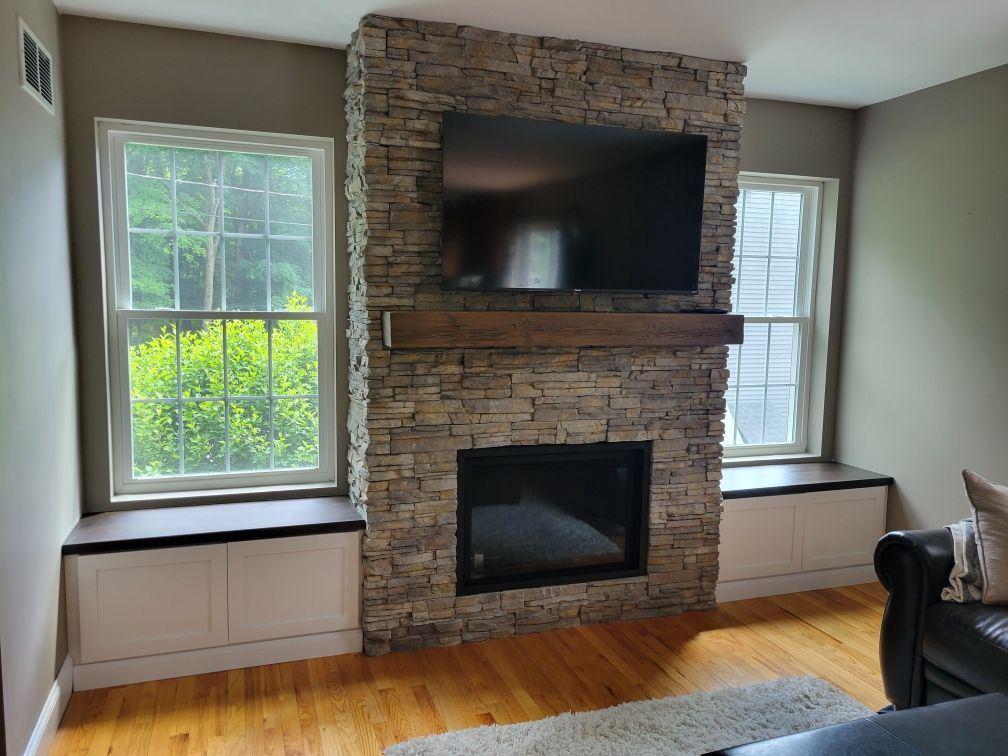 A living room with a fireplace and a flat screen tv.