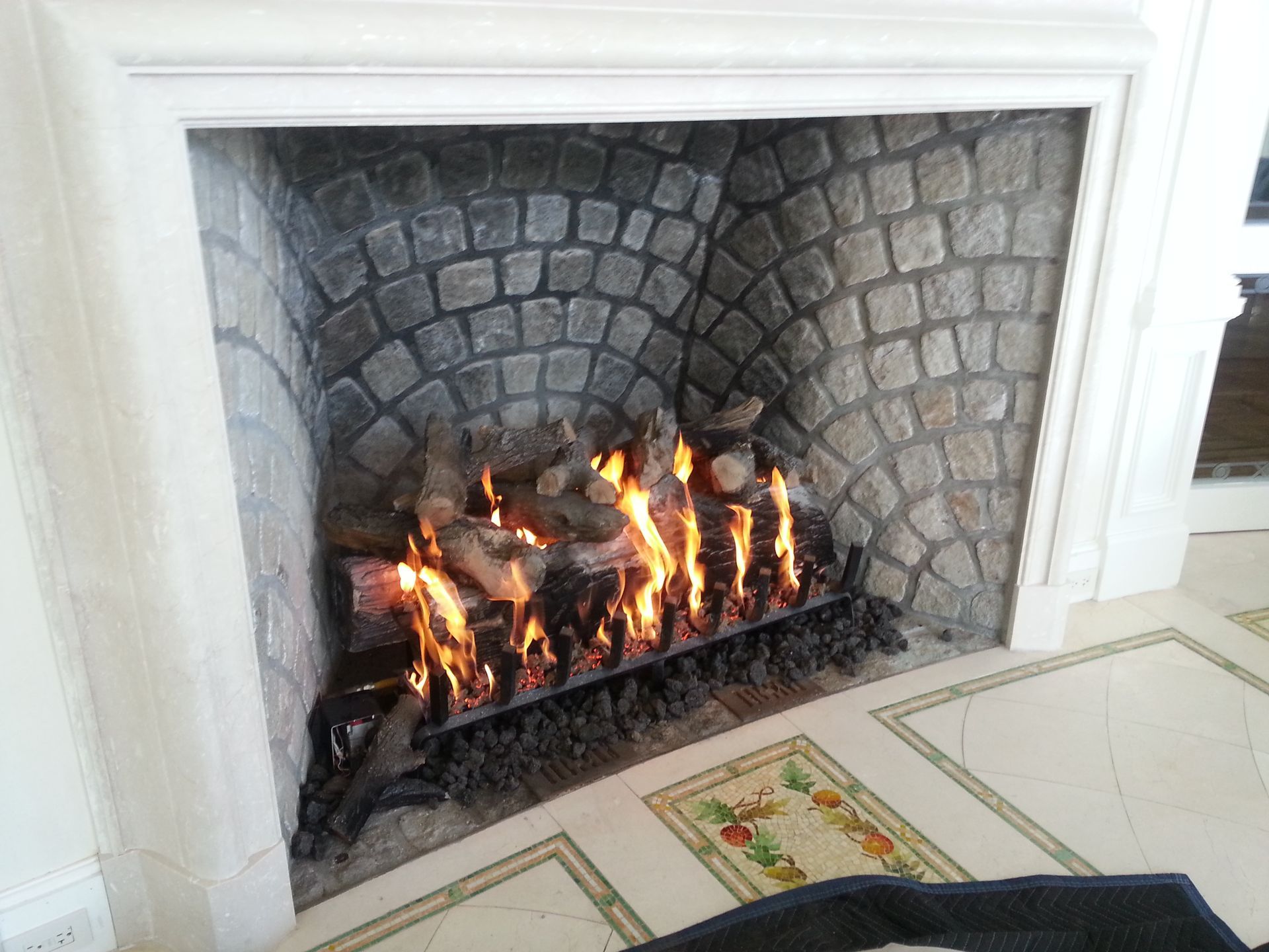 A fireplace in a living room with a brick wall
