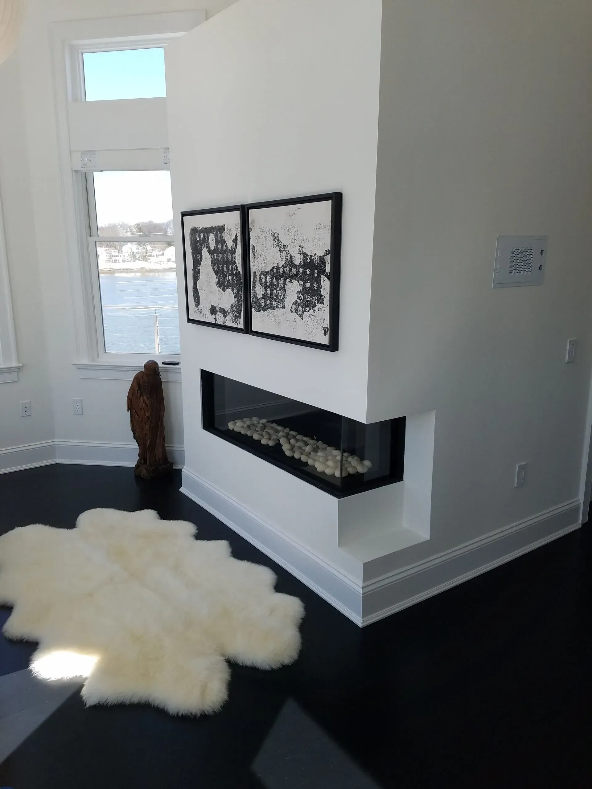 A living room with a fireplace and a rug on the floor.