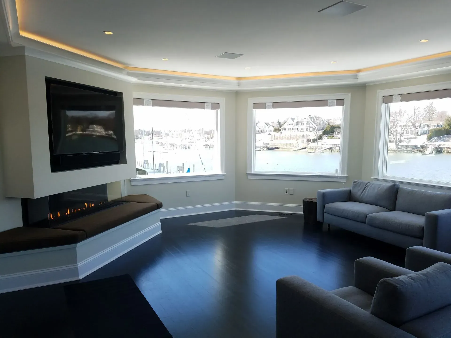 A living room with a couch, chair, fireplace and television.