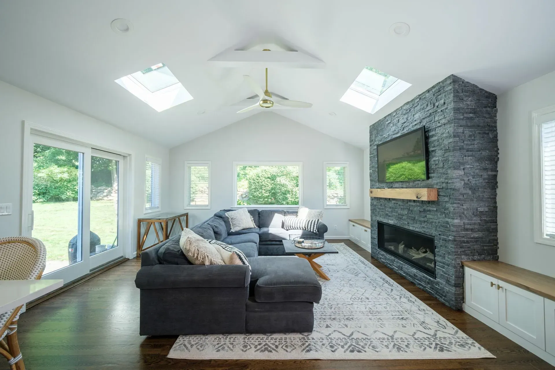 A living room with a couch, fireplace and television.